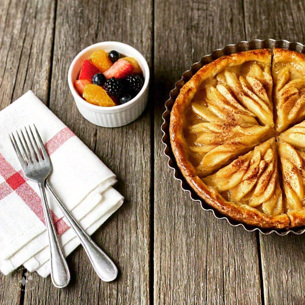 A slice of apple pie and a bowl of fresh fruit salad on a wooden table  