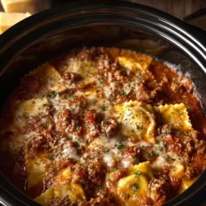 Crockpot ravioli lasagna layered with sauce, cheese, and pasta in a slow cooker.